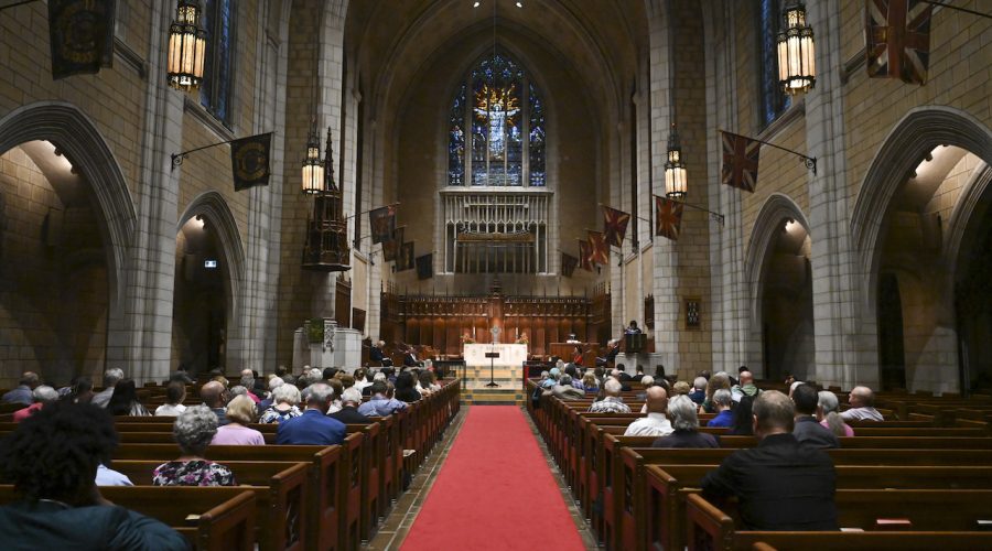 A joyous moment from the 2024 Convocation at the Church of St. Andrew and St. Paul, showing graduates in caps and gowns celebrating with faculty and family.